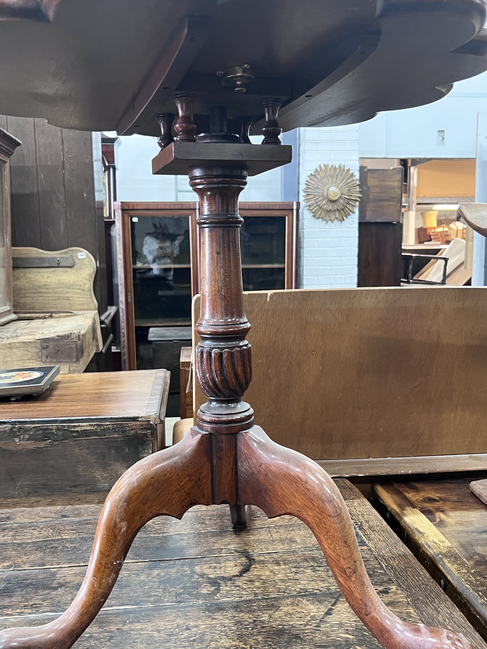 A George III style circular yew tilt top tripod tea table, diameter 65cm, height 68cm